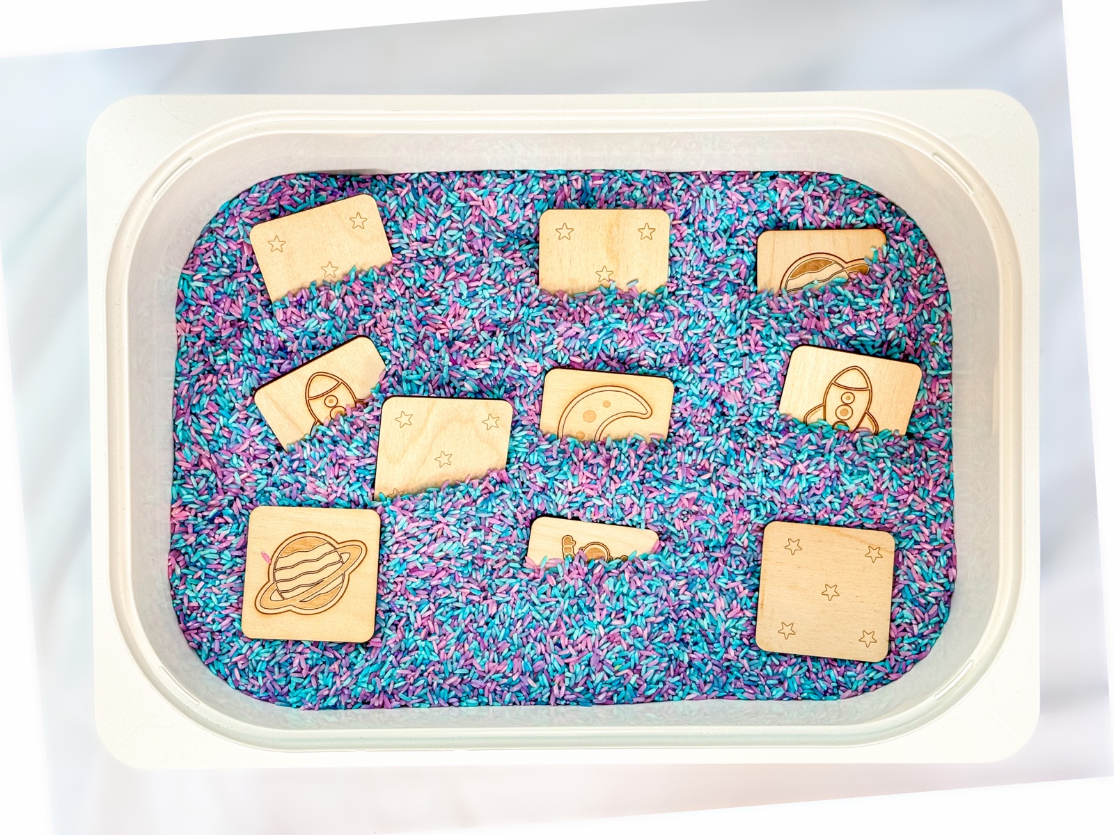 Space memory match tiles hidden in a sensory bin