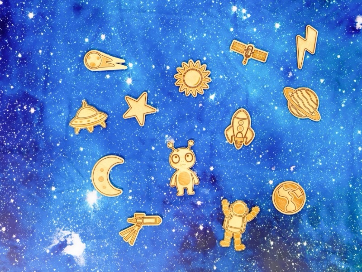 Wooden space playscape pieces arranged on a starry galaxy background