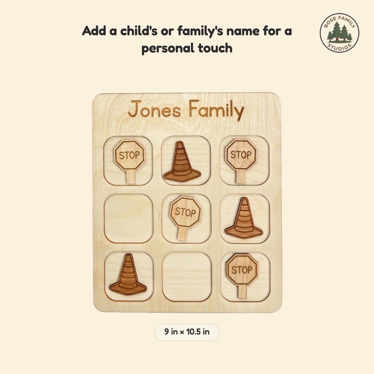 Size reference graphic for the construction tic tac toe board engraved 'Jones Family' at 9 x 10.5 in, showing laser-engraved traffic cone and stop sign pieces in neutral Baltic birch across the three-by-three grid