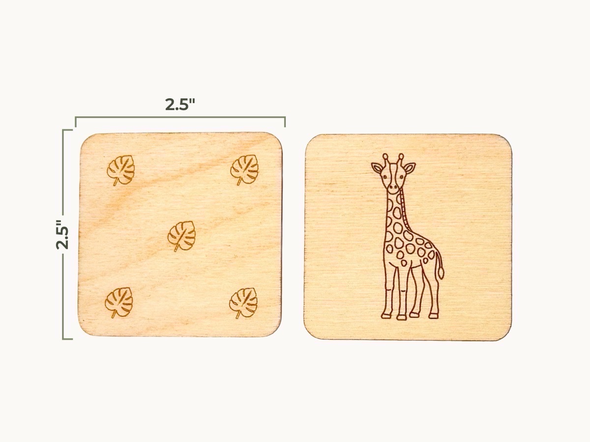 A single wooden giraffe tile marked 2.5 inches square, shown beside its reverse side engraved with a leaf design in the four corners and center, on a white fabric background